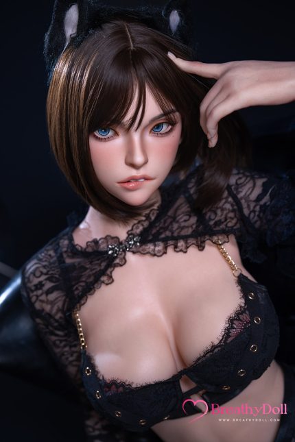 A realistic doll with blue eyes, short brown hair, and black lace clothing, wearing black cat ears, posing with her hand near her head against a dark background.